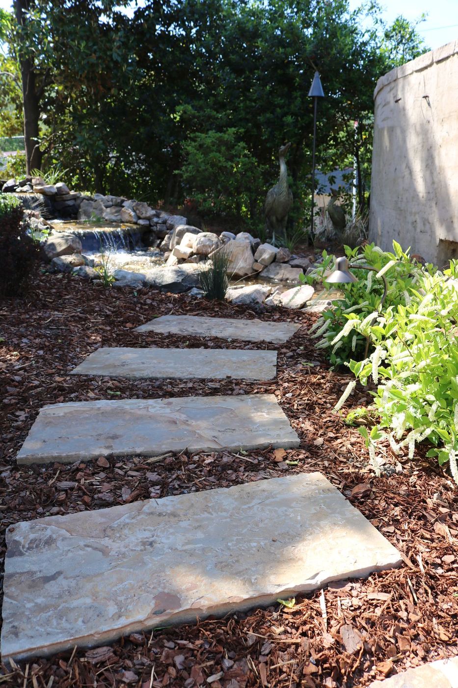 Flagstone stepping-stone path beside a recirculating rock stream